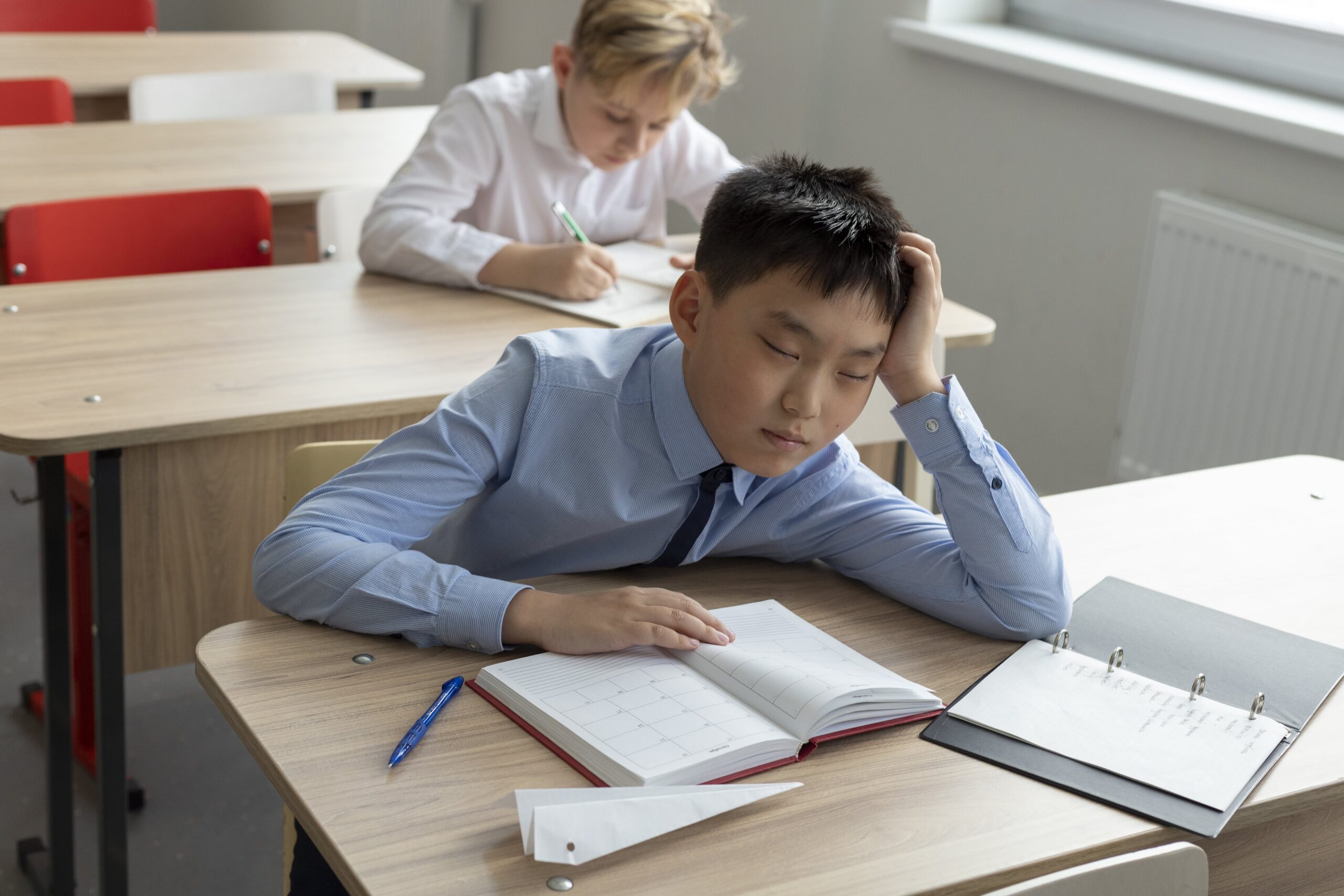 Medium shot boy sleeping school min